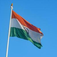 India flag flying high at Connaught Place with pride in blue sky, India flag fluttering, Indian Flag on Independence Day and Republic Day of India, tilt up shot, Waving Indian flag, Har Ghar Tiranga photo