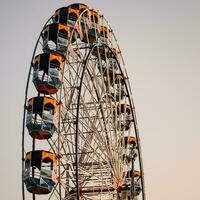 Closeup of multi-coloured Giant Wheel during Dussehra Mela in Delhi, India. Bottom view of Giant Wheel swing. Ferriswheel with colourful cabins during day time. photo