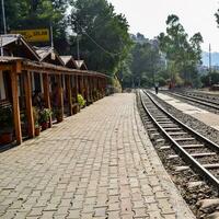 Shimla, Himachal Pradesh, India - August 14, 2023 - Toy train Kalka-Shimla route, moving on railway to the hill, Toy train from Kalka to Shimla in India among green natural forest photo