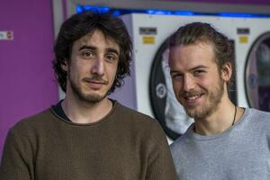 portrait of handsome millennial friends are waiting washing clothes photo