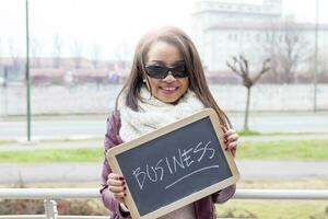 young attractive businesswoman shows a blackboard marked with business concepts photo