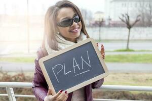 young attractive businesswoman shows a blackboard marked with business concepts photo