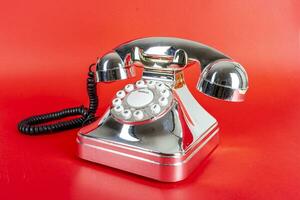 chrome vintage telephone on a red background photo