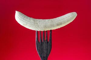 peeled banana skewered on a wooden fork photo