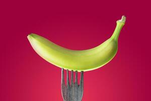 banana with peel skewered on a wooden fork photo