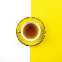 amarillo té taza en un blanco y amarillo antecedentes foto