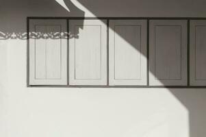 Sunlight and shadow on surface of wooden windows on cement wall of vintage house in sepia tone style photo