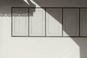 Sunlight and shadow on surface of wooden windows on cement wall of vintage house in sepia tone style photo