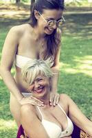 mother and daughter while posing hugged together in swimsuit photo