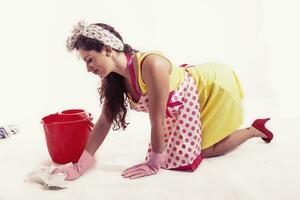 pretty housemaid with cloth and bucket cleaning the floor photo