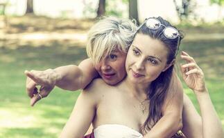 mother and daughter while posing hugged together in swimsuit photo