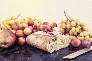 bread and grapes on white wall background photo