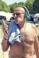 Mature modern man listens to music with headphones photo