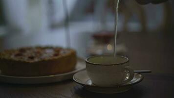 un niña vierte té en el mesa pastel y velas video