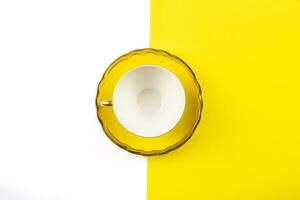 empty yellow teacup on white and yellow background photo