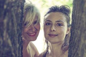 mother and daughter while posing hugged together in swimsuit photo