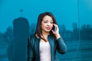 pretty business woman talking on mobile smartphone outside photo