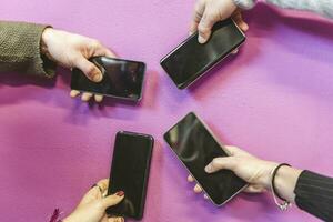 group of people addicted having fun together using smart phones photo