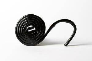 Roll spiral of black licorice isolated on white photo