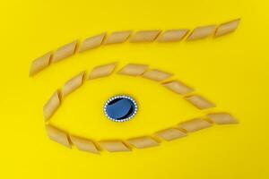 group of pasta lined up in the shape of an eye with a jewel in the center photo