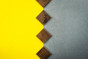 chocolate bars create geometric shapes on a yellow and gray background photo