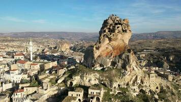 aéreo zumbido ver de el ortahisar castillo en capadocia, Turquía con el nieve tapado montar erciyes en el antecedentes. personas disfrutando el ver desde el parte superior de el castillo. video