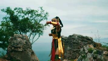 a female knight with long hair practicing kungfu around a large rock video