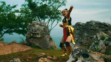 uma fêmea cavaleiro com grandes cabelo praticando kungfu por aí uma ampla Rocha video