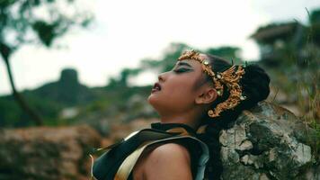 a female knight was resting and leaning against a boulder with a tired face video