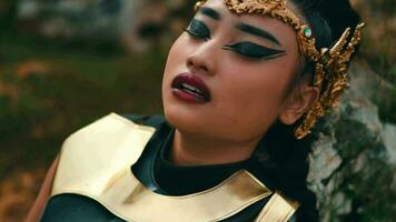 a female knight was resting and leaning against a boulder with a tired face video