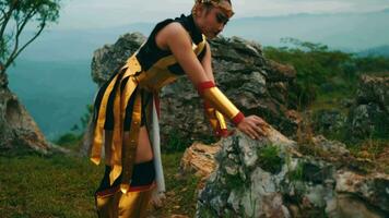 a female warrior in golden armor was practicing martial arts on a mountain video