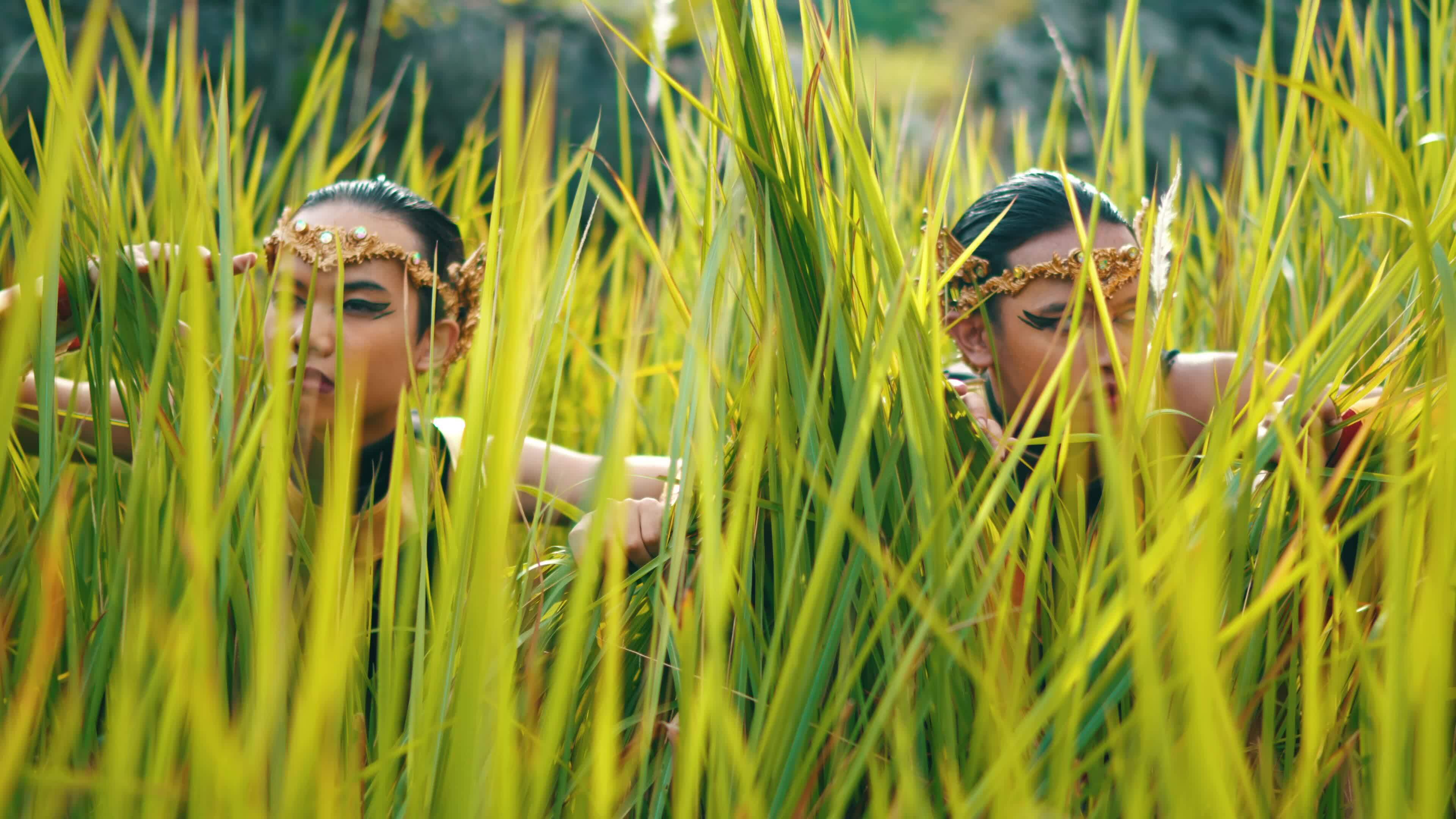 two male soldiers in golden costumes hiding in the green bushes