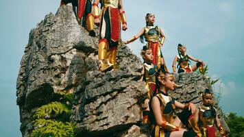 ein Gruppe von königlich Ritter war Stehen auf ein Felsen Cliff während tragen golden Rüstung Kostüme video