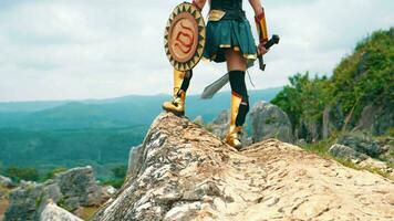 a female warrior holding a sword and golden shield standing on a cliff very bravely video