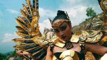 a warlord in a golden wing costume stands boldly and decisively on a cliff with white clouds video