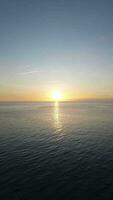 Vertical Aerial Footage of Ocean Waves at Sunset. The Sun Sets Over the Calm Ocean Waves video