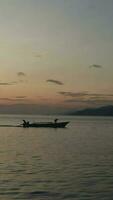 verticale metraggio di pesca Barche attraversamento il mare a tramonto video