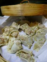 Steaming shumai dim sum in a bamboo steamer photo
