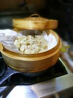 Steaming shumai dim sum in a bamboo steamer photo