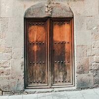 un medieval cerrado puerta con hierro guarniciones en un Roca pared. típico arquitectura de Europa. foto