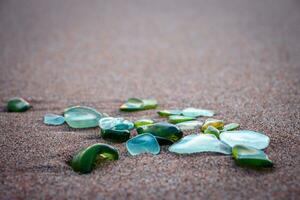 Sand beach and glass stones concept photo. Glass stones from broken bottles polished by the sea. photo