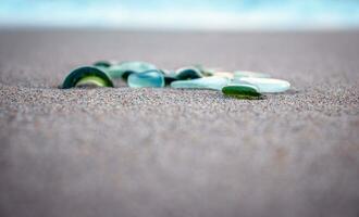 Sand beach and glass stones concept photo. Glass stones from broken bottles polished by the sea. photo