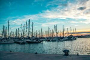 Sailboat harbor in the port evening photo. Beautiful moored sail yachts in the sea photo