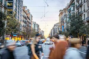 Busy crowds in motion blurred shoppers on Barcelona street. Old apartment building near road. photo