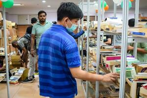 Delhi, India, September 09 2023 - Various age group people reading variety of Books on shelf inside a book-stall at Delhi International Book Fair, Selection of books on display in Annual Book Fair photo
