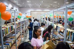 Delhi, India, September 09 2023 - Various age group people reading variety of Books on shelf inside a book-stall at Delhi International Book Fair, Selection of books on display in Annual Book Fair photo