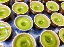 a tray of green tea cups with a spoon photo