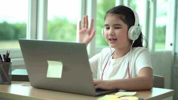 niño niña sonrisa disfrutar e-learning en computadora cuaderno con para risa a gracioso comunicación y estudiar en línea o aprender desde hogar a jugar ordenador portátil por espalda a colegio video