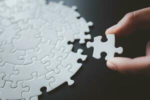 Closeup hand of woman connecting jigsaw puzzle, Business solutions, success and strategy concept photo
