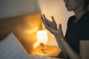 cristiano mujer Orando en dormitorio, mujer manos Orando a dios, mendicidad para perdón y creer en bondad. cristiano vida crisis oración a dios. cristiano vida crisis oración a dios. foto